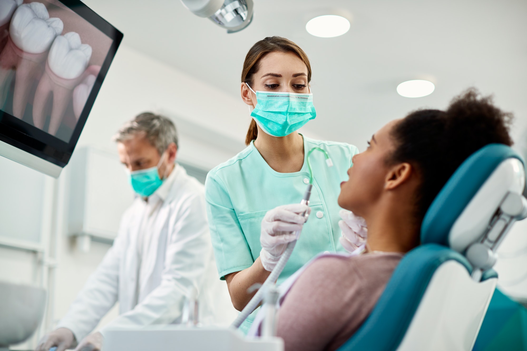 Clear Braces Young nurse preparing patient for dental procedure at dentist's office.